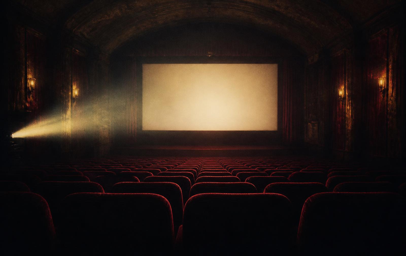 Empty vintage cinema auditorium with a projector beam