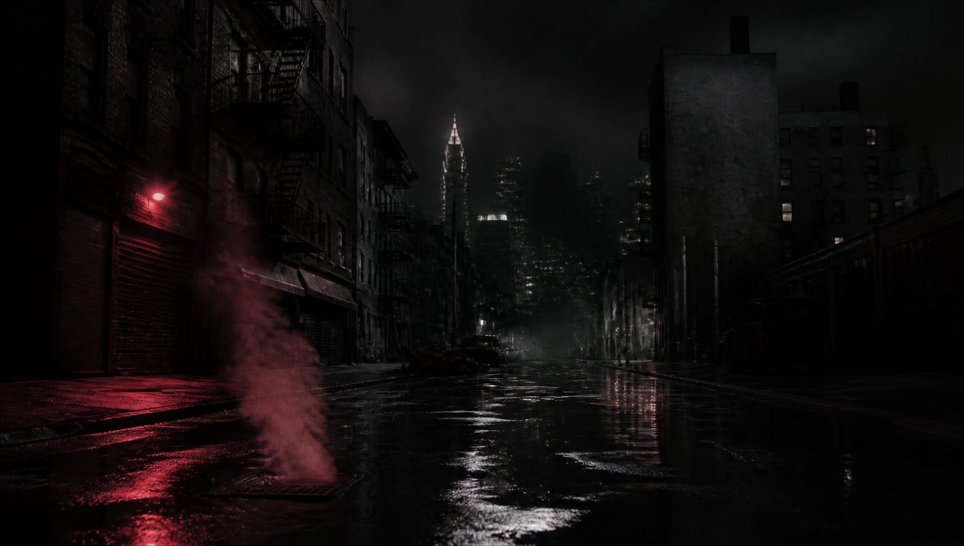 Deserted Manhattan street at night, wet pavement and steam under a red light